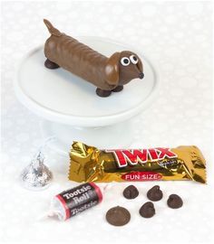 a chocolate dog on a plate next to some candy