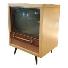 an old fashioned television sitting on top of a wooden stand