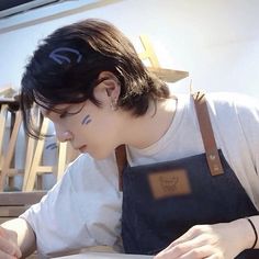 a person sitting at a table writing on a piece of paper