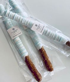 three candy sticks wrapped in plastic on top of a table