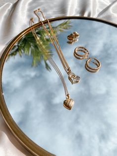 a mirror with jewelry on it and a palm tree in the reflection