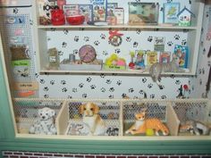 there are many dogs and cats in this toy display case on the shelf above them