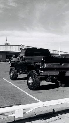 a black and white photo of a truck in a parking lot