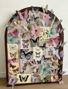 a wooden frame filled with lots of butterflies