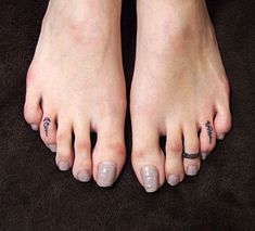 a person with two tattoos on their feet and one has a ring around her ankle