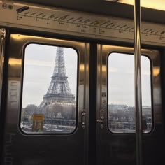 the eiffel tower is seen through two open doors in this train car window