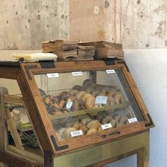 a display case filled with lots of different types of bread and pastries on top of wooden tables