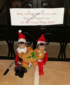 two elfs holding a gingerbread man and a sign that says run, he was fast as you can