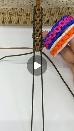 a person is holding two pieces of string with different colors on it and the strings are connected to each other