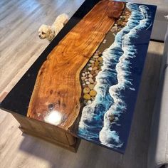 a coffee table with an ocean scene painted on the top and rocks in the bottom