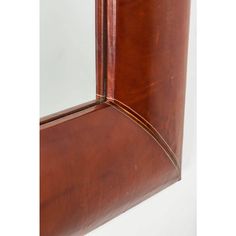 a close up view of the corner of a brown leather book case with an open door