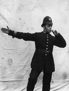 black and white photograph of a man in uniform with his arms stretched out to the side