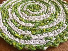 a green and white rug sitting on top of a wooden floor