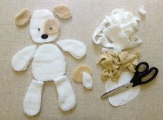 the stuffed animal is next to scissors and other items on the table, which are laid out