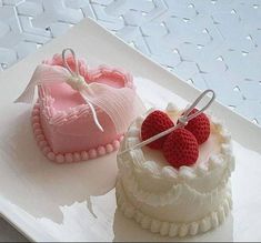 two heart shaped cakes sitting on top of a white platter next to each other