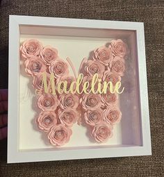 a butterfly made out of pink paper with the word madeleine in gold foil on it