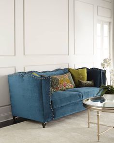 a living room with a blue couch and coffee table in front of a white wall