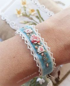 a close up of a person's arm wearing a bracelet with flowers on it