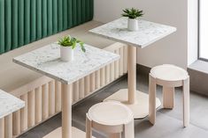 three tables and stools with plants on them