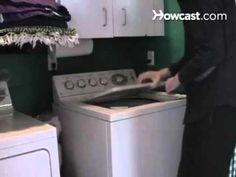 a man is standing in front of the washer and looking at something on the dryer