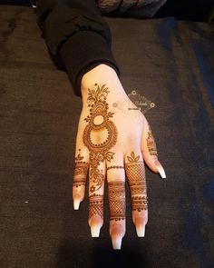 a woman's hand with henna tattoos on it