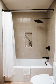 a white bath tub sitting next to a toilet