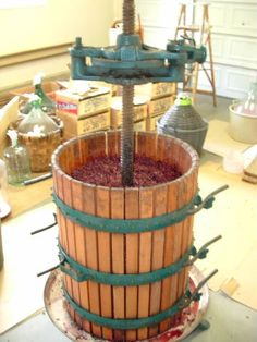 a wooden barrel filled with red wine sitting on top of a table