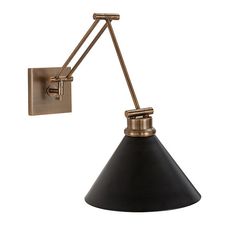 a black and brass wall light with an adjustable arm, on a white background the lamp is dimmed