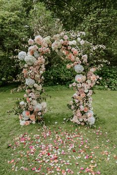 an arch made out of flowers in the grass