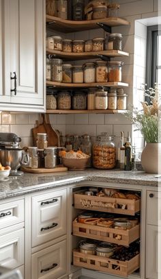 an organized kitchen with white cabinets and lots of food in the pantry area, including bread