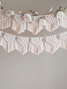 a white crocheted garland with flowers and leaves