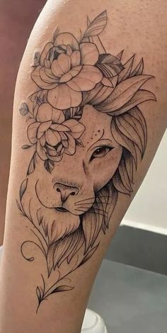 a woman's thigh with a lion and flowers on her head in black ink