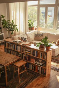 a living room filled with furniture and bookshelves next to a window covered in plants