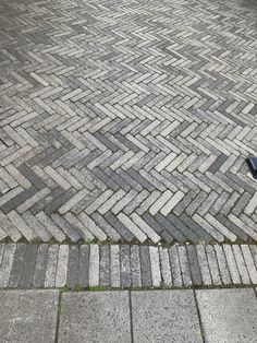 an umbrella is sitting on the sidewalk next to a brick walk way that looks like it's made out of bricks