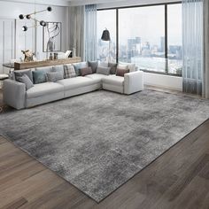 a living room with a large gray rug in front of a window and a couch