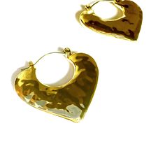 These Hammered Heart Hoop Earrings offer the perfect blend of fashion-forward style and playfulness. The textured design adds a unique touch, making them a versatile option for any outfit. Easy to wear and sure to turn heads, these earrings are a must-have for any jewelry collection. Length: 1" Gold Plated Zinc alloy. Gold plated. Store away from direct sunlight and water. Do wear in water. Smart Glass, Stocking Fillers For Him, Heart Hoop Earrings, Versatile Jewelry, Stocking Fillers For Her, Ring Watch, Forever Jewelry, Cuff Earrings, Beauty Bag