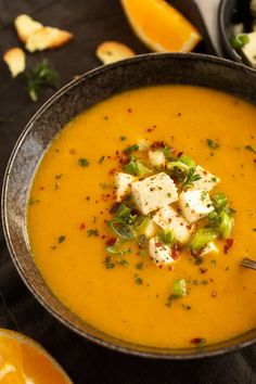 a bowl of soup with tofu cubes and garnishes on top