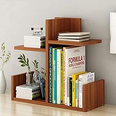 a bookshelf with several books on top of it in front of a white wall