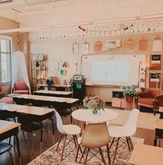 an empty classroom with desks, chairs and a projector screen in the corner