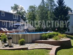 an above ground pool surrounded by landscaping