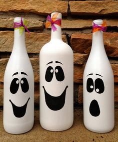 three white bottles with faces painted on them