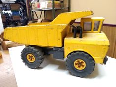 a yellow toy truck sitting on top of a table