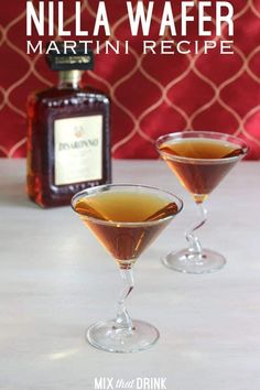 two glasses filled with liquid sitting on top of a table