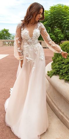 a woman in a wedding dress is standing outside