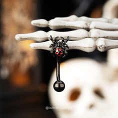 a skeleton hand holding a red and black nose ring