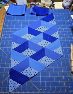 a cutting board with blue fabric on top of it next to scissors and other crafting supplies