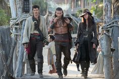 pirates of the carraige are walking down the street with their hands in their pockets