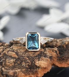 ❤ This stunning engagement ring features a mesmerizing 6x8mm radiant cut natural London blue topaz at its center, capturing the essence of elegance and sophistication. The rich, deep blue hue of the topaz is reminiscent of the depths of the ocean, exuding a sense of tranquility and serenity. Crafted with exquisite attention to detail, the topaz is securely set within a delicate prong or bezel setting, allowing maximum light to enter and illuminate its facets, creating a captivating play of color Luxury Modern Topaz Ring With Prong Setting, Light Blue Topaz Engagement Ring, Rectangular Topaz And Diamond Ring For Anniversary, Rectangular Diamond Topaz Ring For Anniversary, Anniversary Solitaire Topaz Ring Radiant Cut, Radiant Cut Solitaire Topaz Ring For Anniversary, Anniversary Radiant Cut Solitaire Topaz Ring, Fine Jewelry Anniversary Topaz Ring Radiant Cut, Fine Jewelry Radiant Cut Topaz Ring For Anniversary