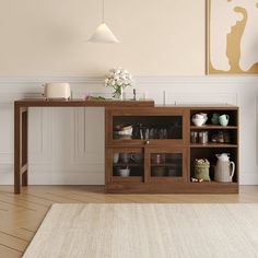 a living room with a table and shelves on the wall next to a rug in front of it