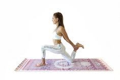 a woman is doing yoga on a rug